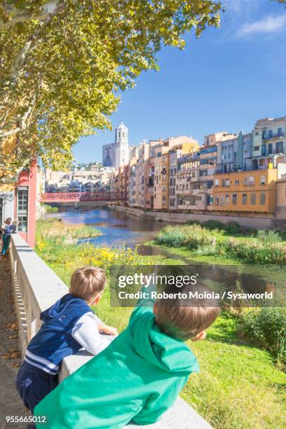 children on the banks of river onyar, girona - fiume onyar foto e immagini stock