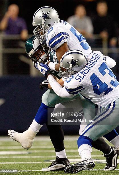 Tight end Brent Celek of the Philadelphia Eagles is tackled by Bradie James and Gerald Sensabaugh of the Dallas Cowboys at Cowboys Stadium on January...