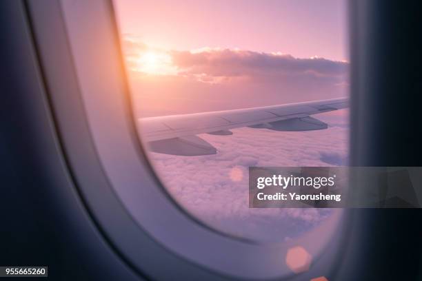 beautiful sunset  look through airplane window - airplane wing stockfoto's en -beelden