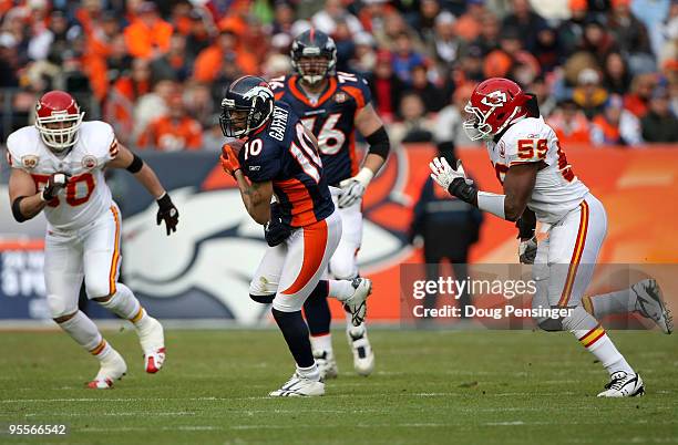 Wide receiver Jabar Gaffney of the Denver Broncos makes a first down reception as Mike Vrabel and Javon Belcher of the Kansas City Chiefs defend...