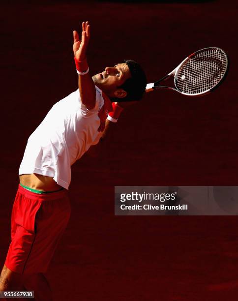 Novak Djokovic of Serbia serves against Kei Nishikori of Japan in their first round match during day three of the Mutua Madrid Open tennis tournament...