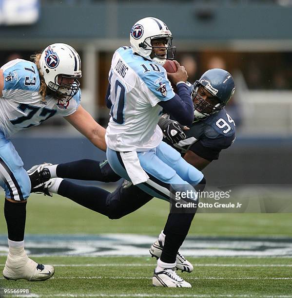 Quarterback Vince Young of the Tennessee Titans rushes against Cory Redding of the Seattle Seahawks on January 3, 2010 at Qwest Field in Seattle,...