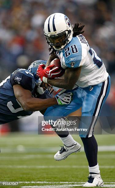 Chris Johnson of the Tennessee Titans runs with the ball against David Hawthorne of the Seattle Seahawks 17-13 at Qwest Field on January 3, 2010 in...