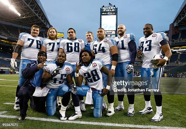 Chris Johnson of the Tennessee Titans poses with his offensive linemen after rushing for 134 yards to break the 2,000-yard mark for the season in...