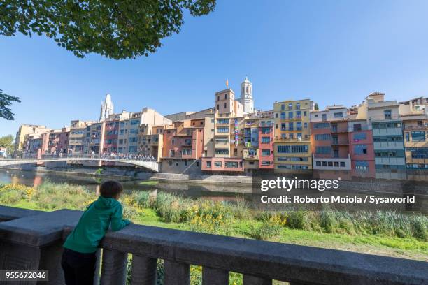 child on riverside look to princess bridge, girona - fiume onyar foto e immagini stock