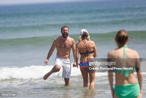 Joe Albani of Shrewsbury, MA reacts to the cold water while taking a dip with Leslie Daniels of Sturbridge, MA at Ogunquit Beach on Wednesday, May 2,...