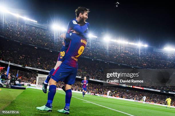 Lionel Messi of FC Barcelona celebrates with his team mate Luis Suarez after scoring his team's second goal during the La Liga match between...