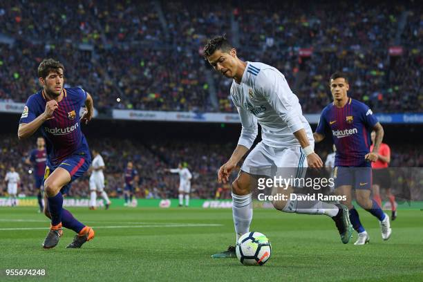 Cristiano Ronaldo of Real Madrid CF competes for the ball with Sergi Roberto of FC Barcelona during the La Liga match between Barcelona and Real...