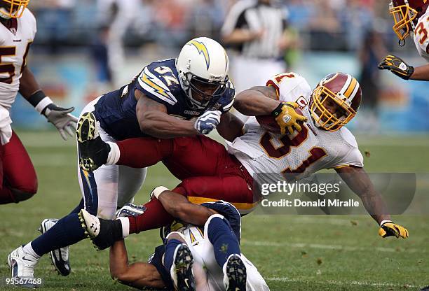 Runningback Rock Cartwright of the Washington Redskins is tackled by Larry English of the San Diego Chargers during their NFL Game on January 3, 2010...