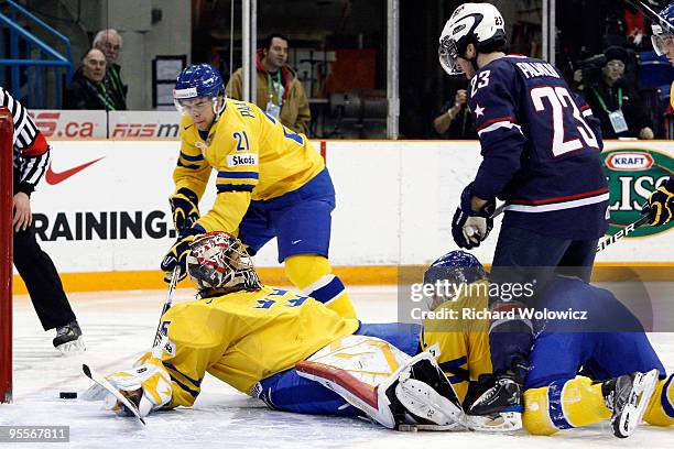 Kyle Palmieri of Team USA pushes down Lukas Kilstrom of Team Sweden knocking down Jacob Markstrom of during the 2010 IIHF World Junior Championship...