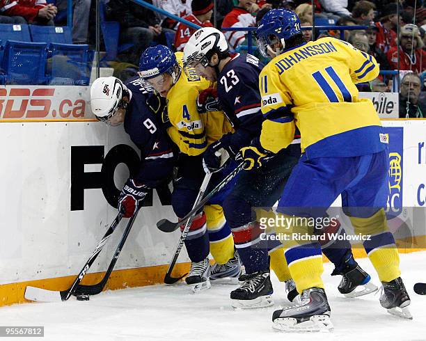 Philip McRae and Kyle Palmieri of Team USA and Tim Erixon and Marcus Johansson of Team Sweden battle for the puck during the 2010 IIHF World Junior...