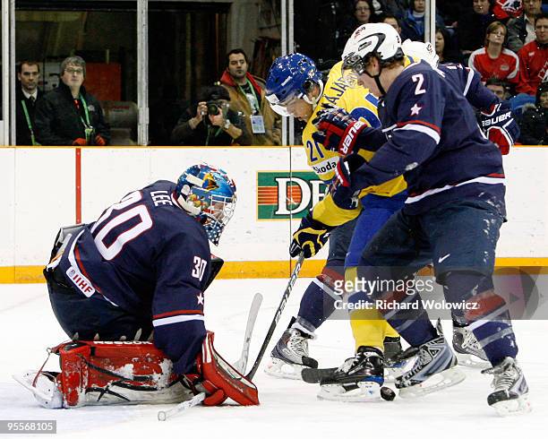 Mike Lee of Team USA watches the loose puck in front of Magnus Svensson Paajarvi of Team Sweden during the 2010 IIHF World Junior Championship...