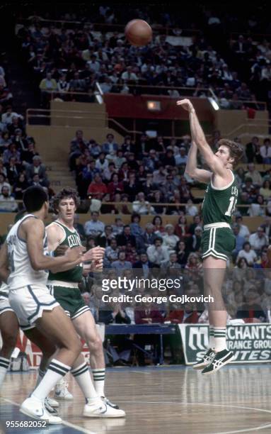 Center Dave Cowens of the Boston Celtics shoots as teammate John Havlicek defends against John Shumate of the Buffalo Braves during a National...