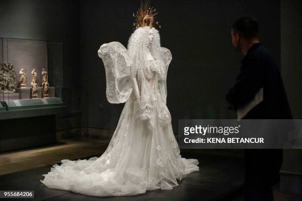 Member off the media observes the dress "Madonna" wedding ensemble by House of Dior during the press preview for the annual fashion exhibition...