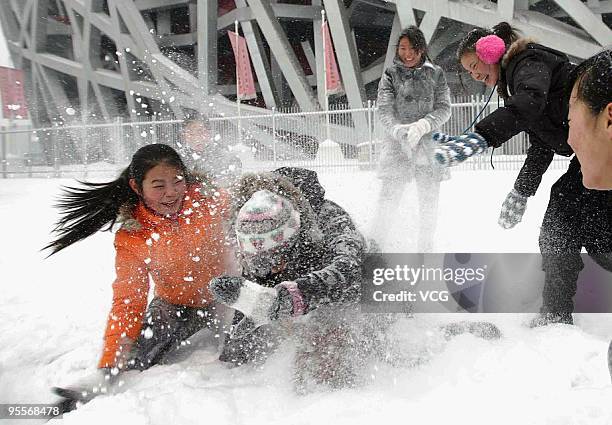 People play in heavy snow at the National Stadium on January 3, 2010 in Beijing, China. The biggest snowfall in nearly 60 years has blanketed Beijing...