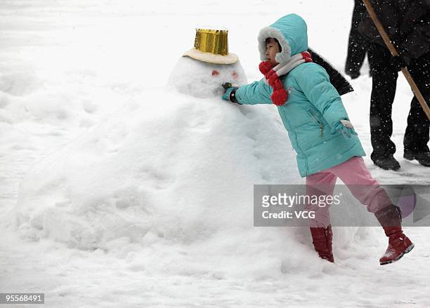 Girl poses with a snowman on January 3, 2010 in Beijing, China. The biggest snowfall in nearly 60 years has blanketed Beijing as snow storms hit...