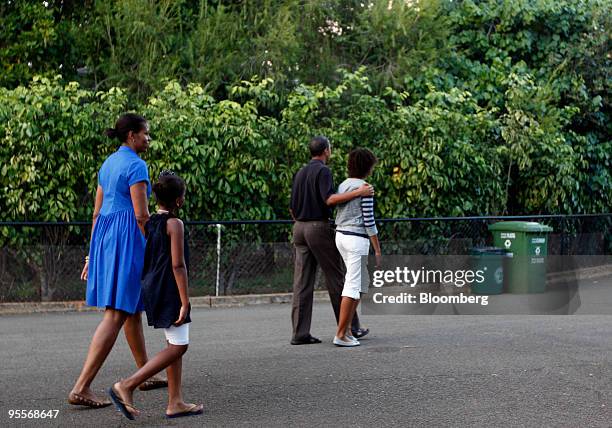 President Barack Obama, second from right, walks with his family, First Lady Michelle Obama, left, and daughters Sasha, and Malia, by the...