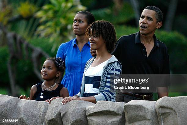 President Barack Obama, right, and his daughter Sasha, left, First Lady Michelle Obama, second left, and his oldest daughter Malia, pause to look at...