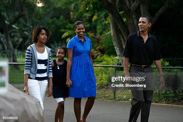 President Barack Obama, right, walks with his daughters Malia, left, Sasha, second from left, and first lady Michelle Obama, by the White-handed...