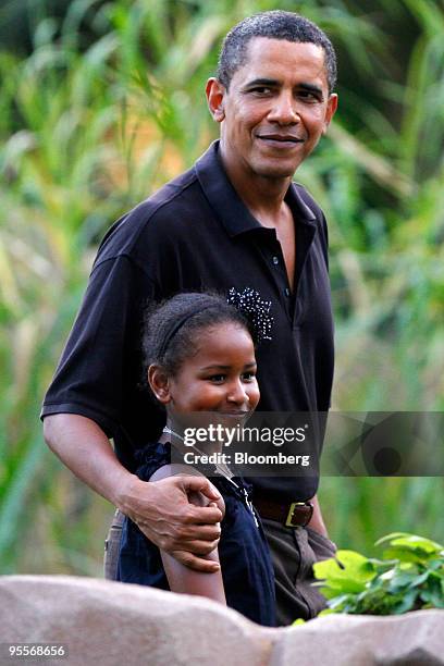 President Barack Obama, right, and his youngest daughter Sasha walk by the White-handed Gibbon exhibit at the Honolulu Zoo in Honolulu, Hawaii, on...