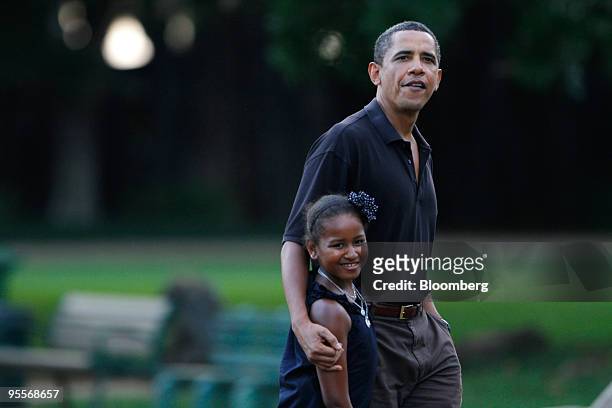 President Barack Obama, right, and his youngest daughter Sasha walk by the White-handed Gibbon exhibit at the Honolulu Zoo in Honolulu, Hawaii, on...