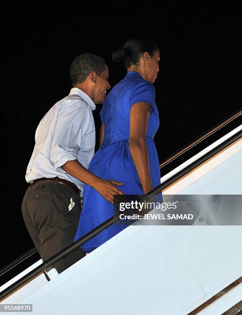 President Barack Obama and first lady Michelle Obama board Air Force One at Hickam Air Force Base in Honolulu, Hawaii on January 3, 2010. The first...