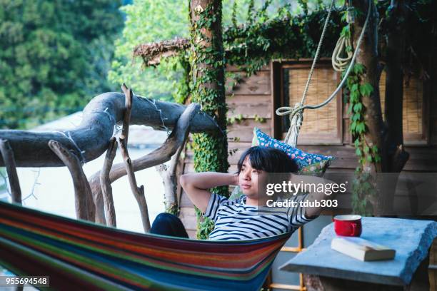 young adult lying in a hammock - tokushima prefecture stock pictures, royalty-free photos & images