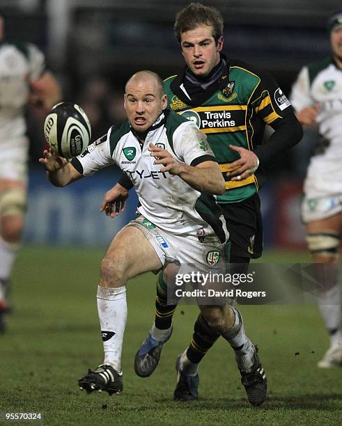 Paul Hodgson of London Irish gathers the loose ball watched by Stephen Myler during the Guinness Premiership match between Northampton Saints and...