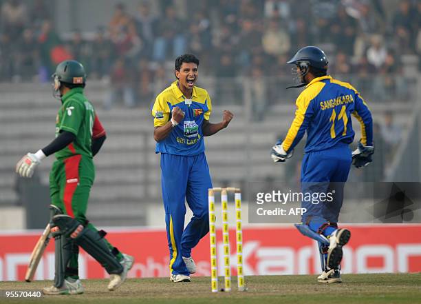 Sri Lankan cricketer Suraj Randiv reacts as captain Kumar Sangakkara looks on after the the dismissal of the Bangladeshi cricketer Mushfiqur Rahim...