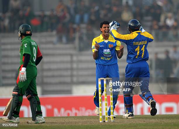 Sri Lankan cricketer Suraj Randiv and captain Kumar Sangakkara celebrate after the the dismissal of Bangladeshi cricketer Mushfiqur Rahim during the...
