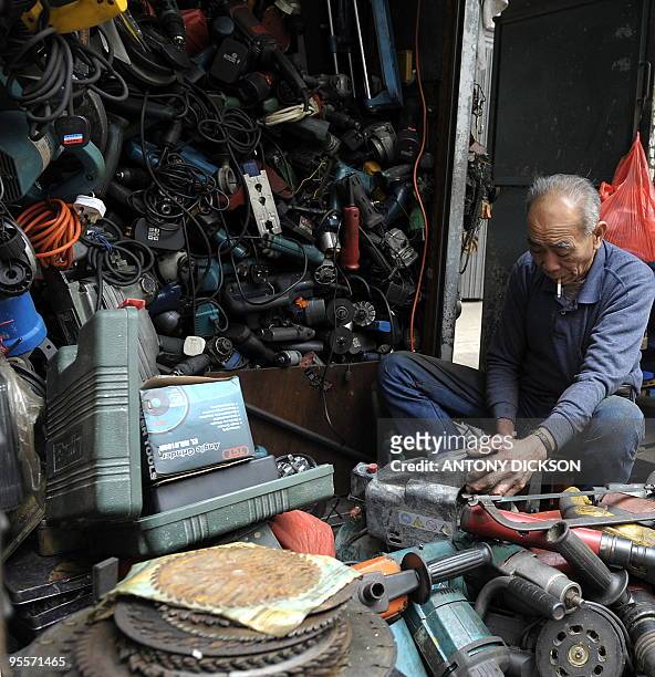 Stall owner works on his tools, before offering them for sale, on a street in Hong Kong on January 2, 2010. Hong Kong's Chief Executive Donald Tsang...