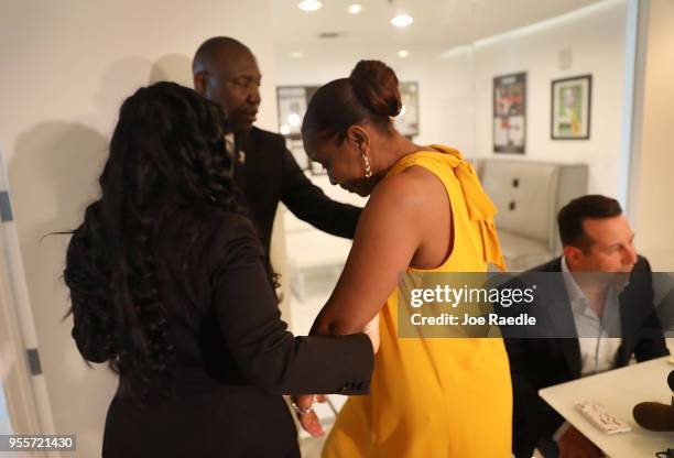 Andrea Goulbourne-Smith is helped by lawyers Jasmine Rand and Benjamin Crump after speaking during a press conference about the announcement that her...