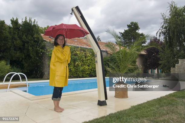 woman with unbrella under outdoor shower - chris sattlberger stock pictures, royalty-free photos & images