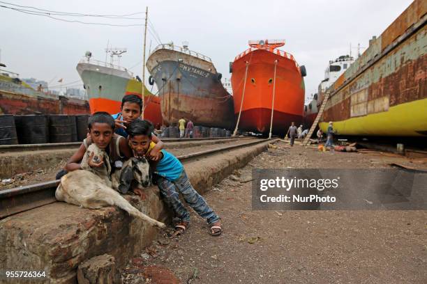 Children poses for photograph with goat in ship propeller making factory in Dhaka, Banhladesh on May 07, 2018.