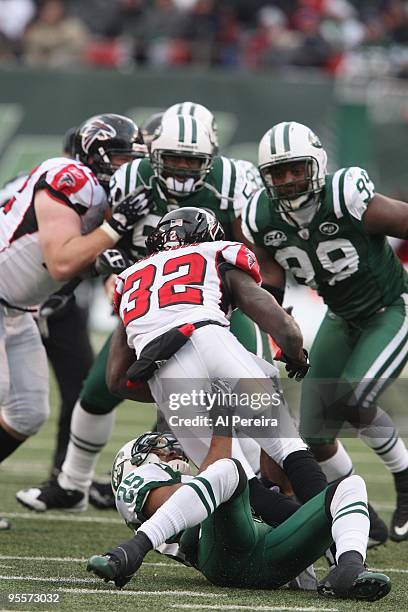 Running Back Jerious Norwood of the Atlanta Falcons is stopped by Safety Kerry Rhodes of the New York Jets at Giants Stadium on December 20, 2009 in...