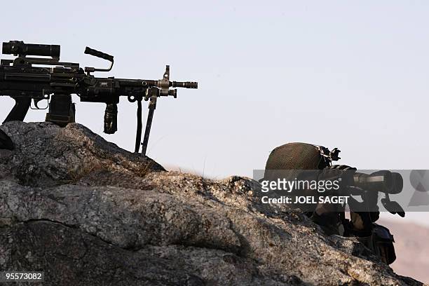 French soldier of the Operational Mentoring and Liaison Teams of the Kandak 32 stands on watch with machine gun Mini-mi over the Alah Say road in...