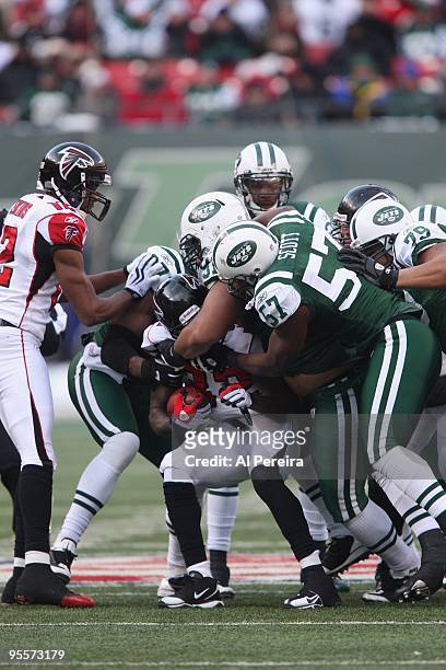 Linebacker Bart Scott, Defensive Tackle Sione Pouha, Linebacker Calvin Pace and Defensive End Ropati Pitoitua of the New York Jets make a gang-tackle...