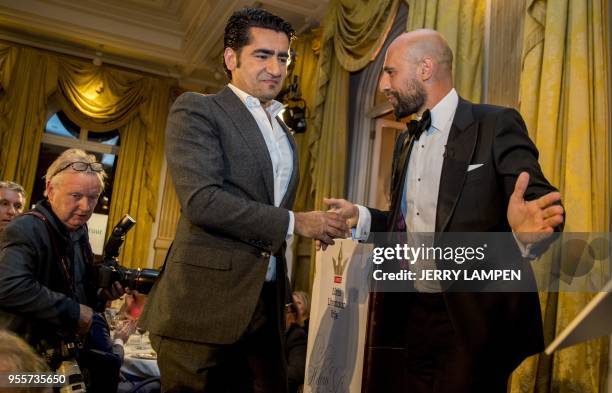 Dutch writer Murat Isik is congratulated after winning the Libris Literature Prize 2018, in Amsterdam, on May 7 for his book 'Wees inzichtbaar'. /...