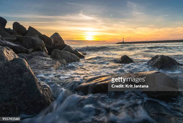 landscape of the sea with waves over the rock and lighthouse at far distant in the morning - chana stock-fotos und bilder