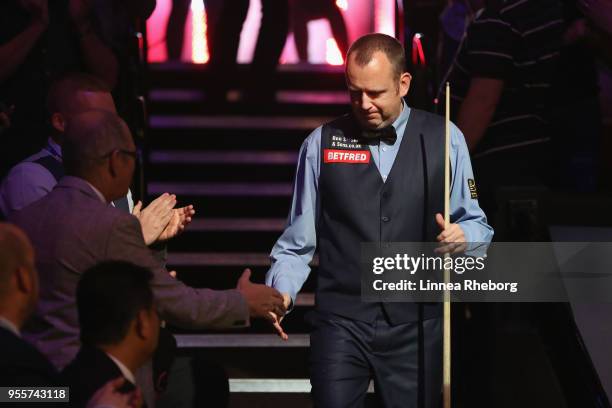 Mark Williams of Wales shakes hands with fans while making his entrance during the fourth session of the final against John Higgins of Scotland...