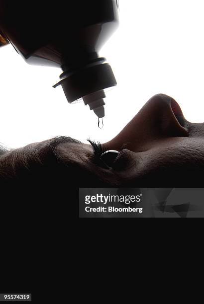 Woman drops Opti-Free Replenish contact lens cleaning fluid into her eye in Paris, France, on Monday, Jan. 4, 2010. Novartis AG offered to buy the...