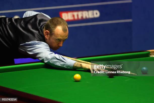 Mark Williams of Wales plays a shot during the fourth session of the final against John Higgins of Scotland during day seventeen of World Snooker...