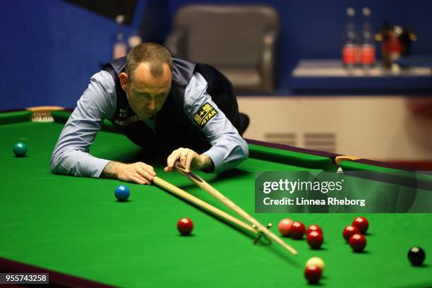 Mark Williams of Wales plays a shot during the fourth session of the final against John Higgins of Scotland during day seventeen of World Snooker...