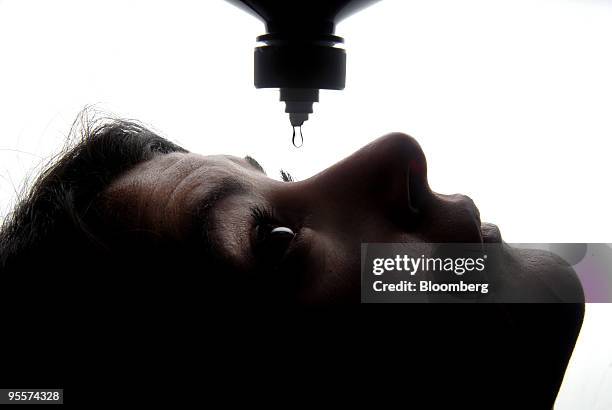 Woman drops Opti-Free Replenish contact lens cleaning fluid into her eye in Paris, France, on Monday, Jan. 4, 2010. Novartis AG offered to buy the...