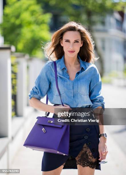 Alexandra Lapp wearing a blue satin skirt with lace by Self-Portrait, a light blue denim shirt by H&M, a purple Kelly bag by Hermes, Denim Jazz Calf...