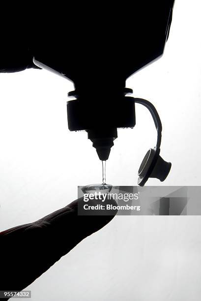 Opti-Free Replenish contact lens cleaning fluid, produced by Alcon Inc., is poured into a contact lens in Paris, France, on Monday, Jan. 4, 2010....