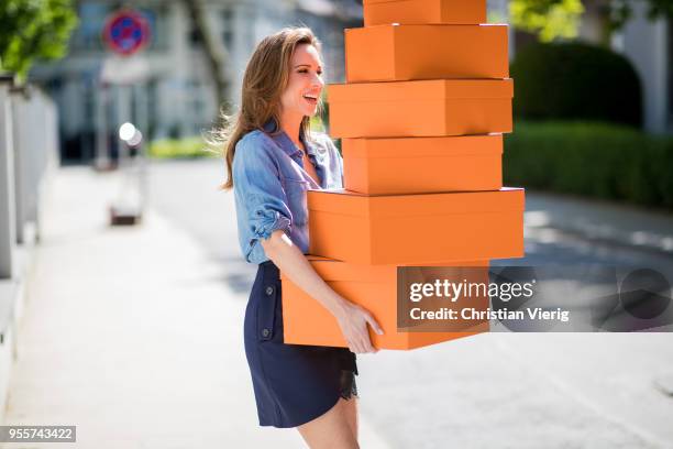 Alexandra Lapp carrying several Hermes cartons wearing a blue satin skirt with lace by Self-Portrait and a light blue denim shirt by H&M on May 5,...