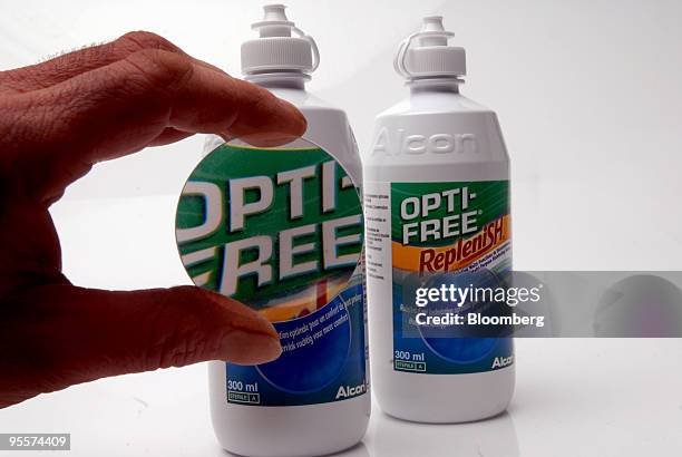 Bottle of Opti-Free Replenish contact lens cleaning fluid, produced by Alcon Inc., is seen through a magnifying glass in Paris, France, on Monday,...