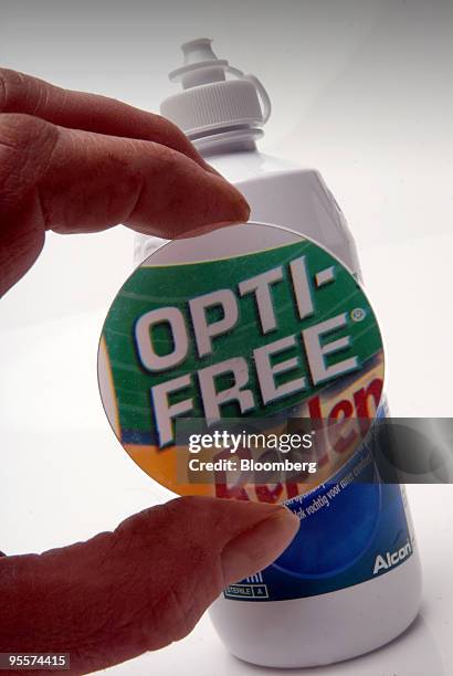 Bottle of Opti-Free Replenish contact lens cleaning fluid, produced by Alcon Inc., is seen through a magnifying glass in Paris, France, on Monday,...