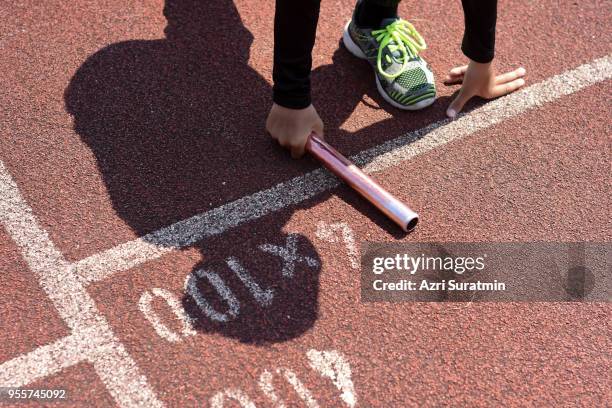 student prepare to leaving the starting for relay race at school sports day. school sports day concept. - track and field baton stock pictures, royalty-free photos & images